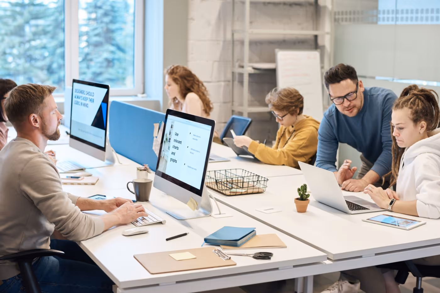 People working at computers in a bright open-plan office