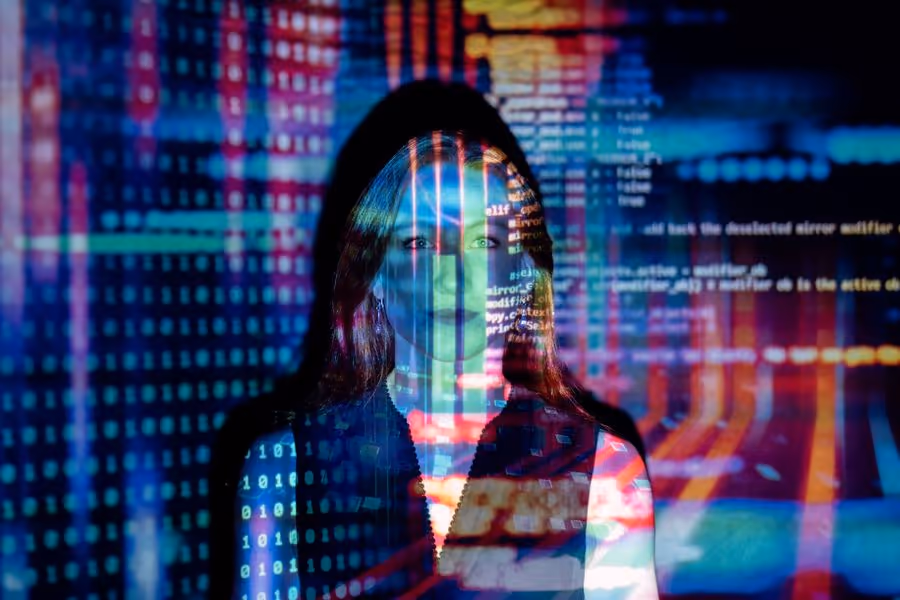 Woman lit by colorful lines of code projected across her face