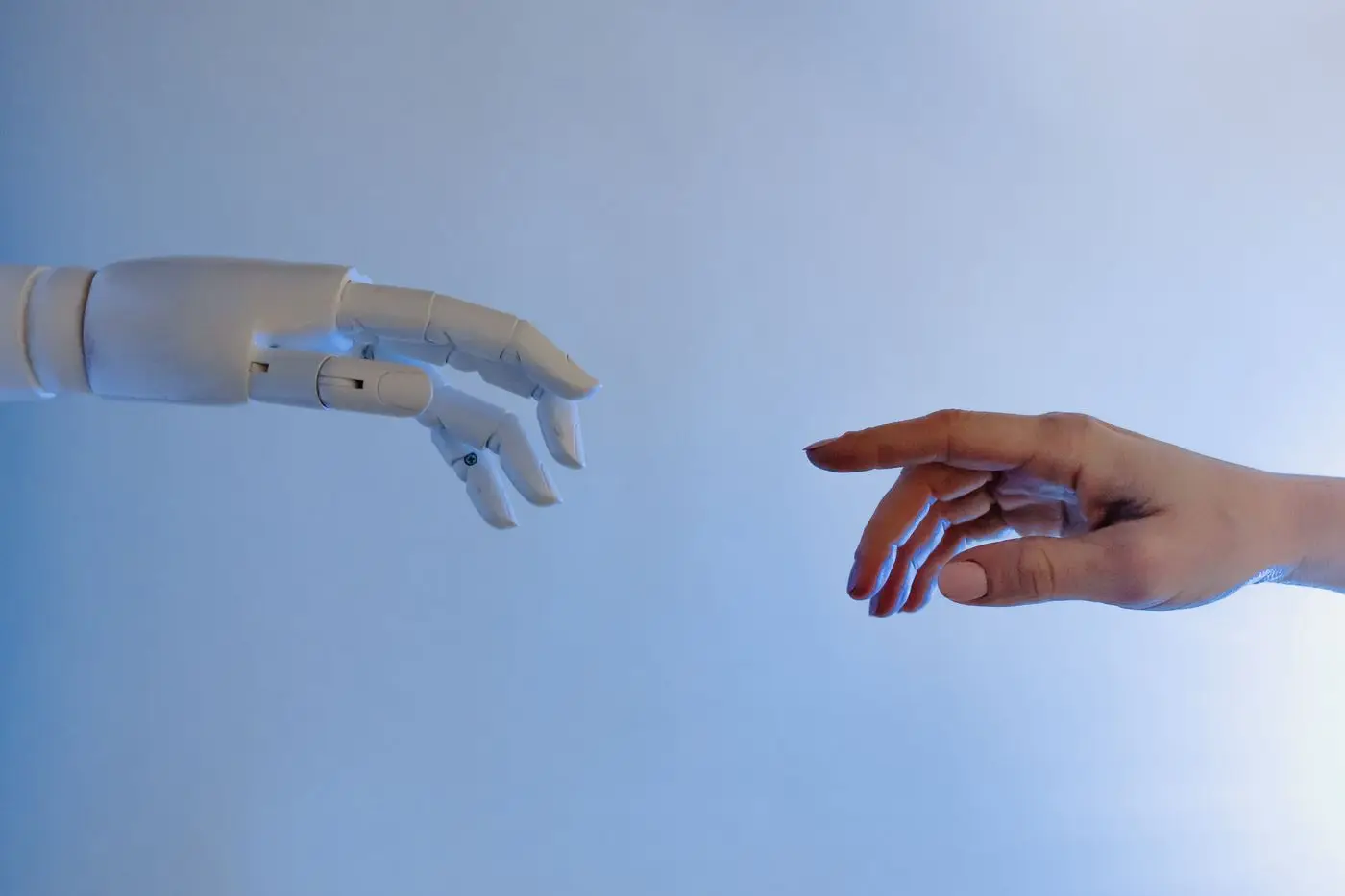Robotic hand and human hand reaching toward each other